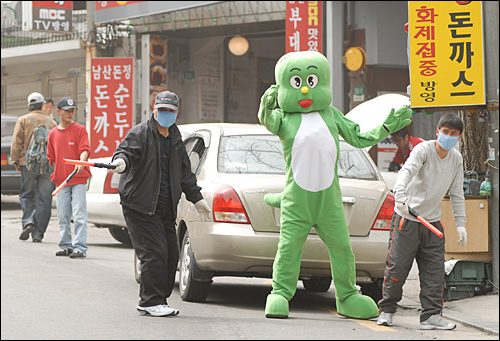 낮 남산의 식당가의 주차안내원들이 황사를 막기 위해 마스크를 쓴채 차량을 유도하고 있다. 